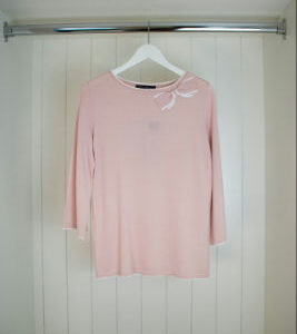 Dünner rosa Pullover mit Schleife.