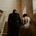 A bride and groom walking down a flight of stairs