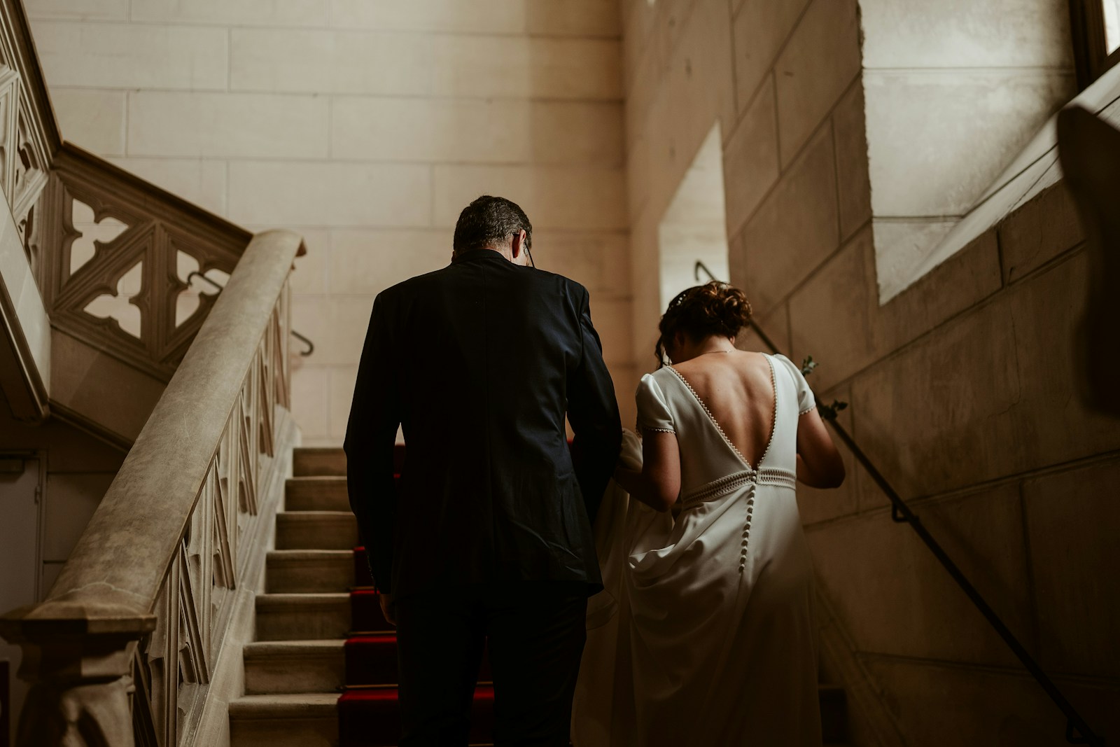 A bride and groom walking down a flight of stairs